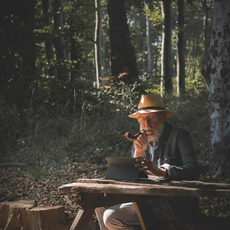 señor mayor recordando en bosque